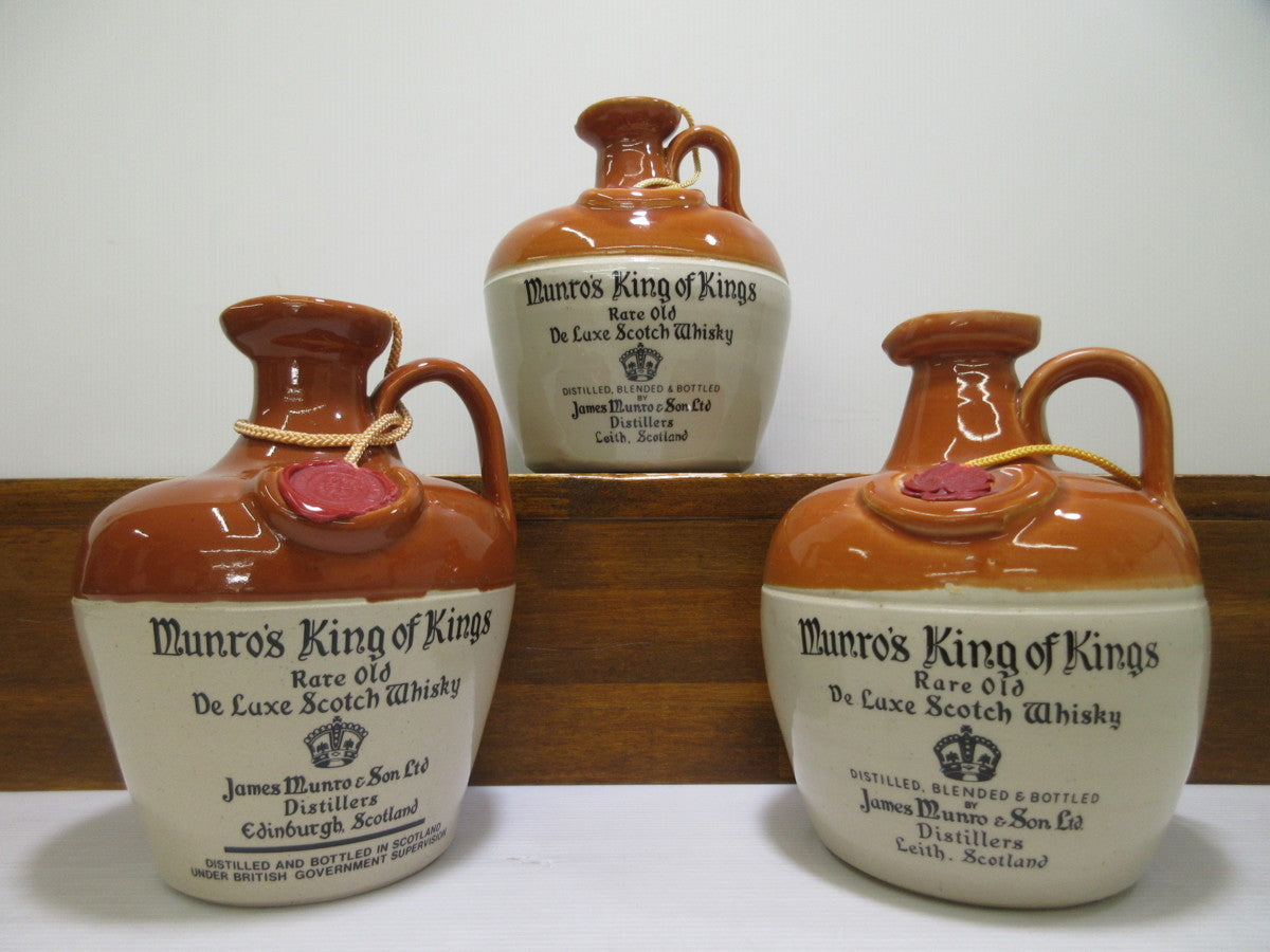 Three bottles of Munro's King of Kings whisky on a white background