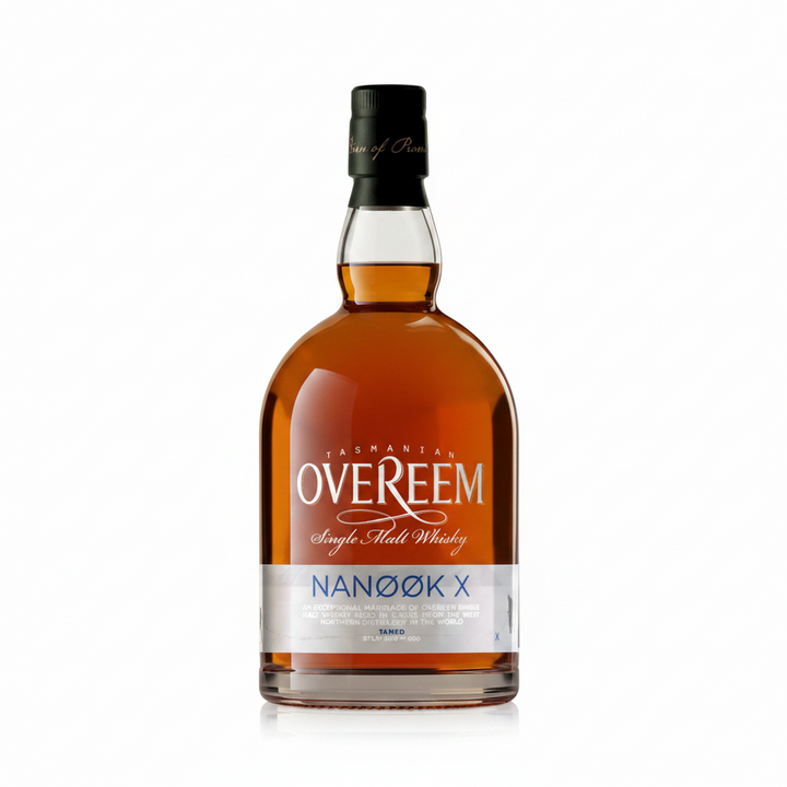 A bottle of Tasmania Overeem Nanook X Single Malt Whisky on a plain white background. The bottle is made of amber glass showing the golden-brown whisky inside, with a black screw cap and a white label featuring silver and gold text.