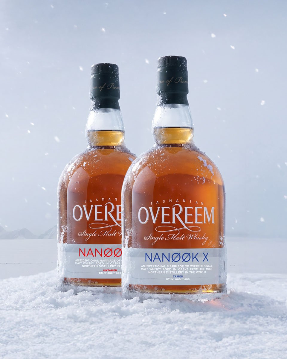 Two bottles of Overeem Single Malt Whisky, including the Nanook X variant, standing in snow with a snowy, misty outdoor background.