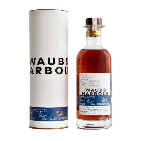 "Waubs Harbour Port Storm Tasmanian single malt whisky bottle and canister set available at Whisky Estate, featuring a sleek design with a rich label that highlights its port cask finish. The clear glass bottle showcases the deep amber whisky, while the matching canister adds a refined presentation, emphasizing the bold, maritime-inspired flavor profile of this Tasmanian whisky."