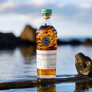 a bottle of Glenglassaugh's 12 Year Old salty and briny, coastal malt whisky from Scotland placed on a rock in a river.