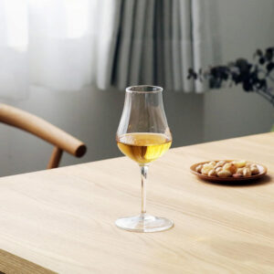 A luxurious Luigi Bormioli whisky glass on a modern timber table accompanied by roasted mixed nuts - Whisky Estate