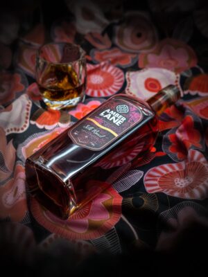 A bottle and glass of Amber Lane Silk Road Australian Single Malt Whisky placed over ornate silk - Whisky Estate